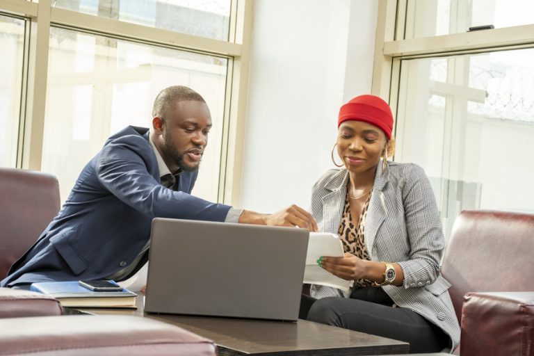 Young black businessman and woman going through some paperwork together